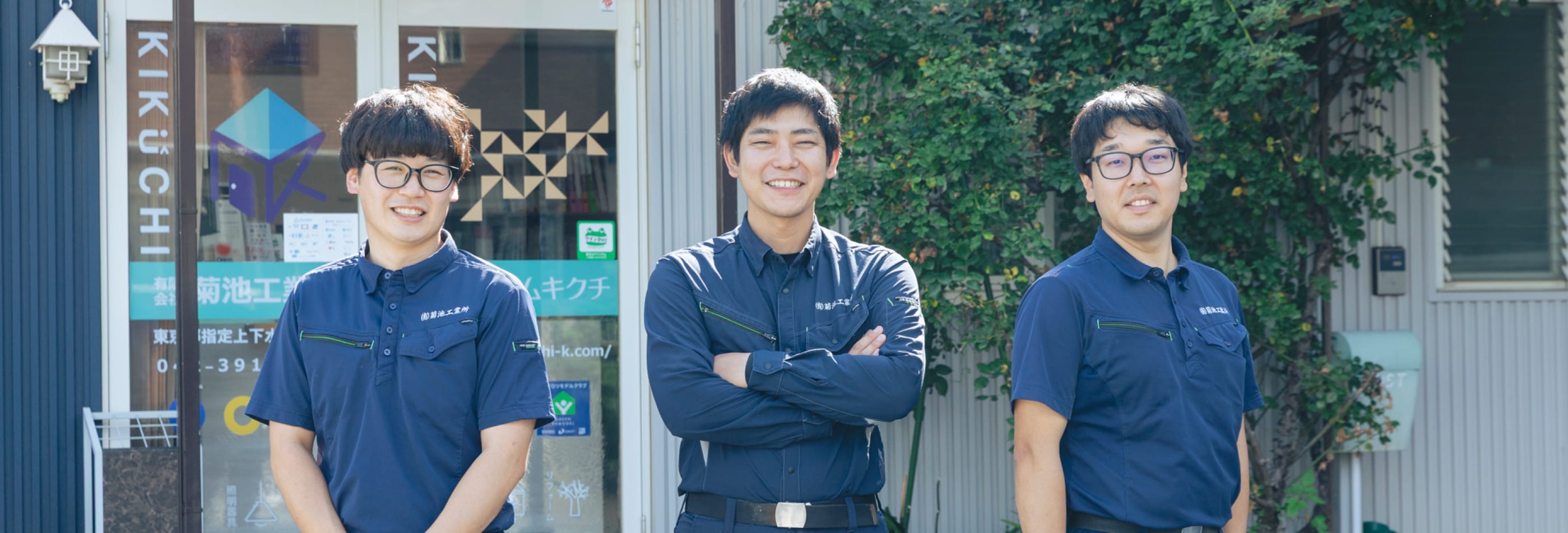  社員たちが笑顔で腕を組んでいる写真