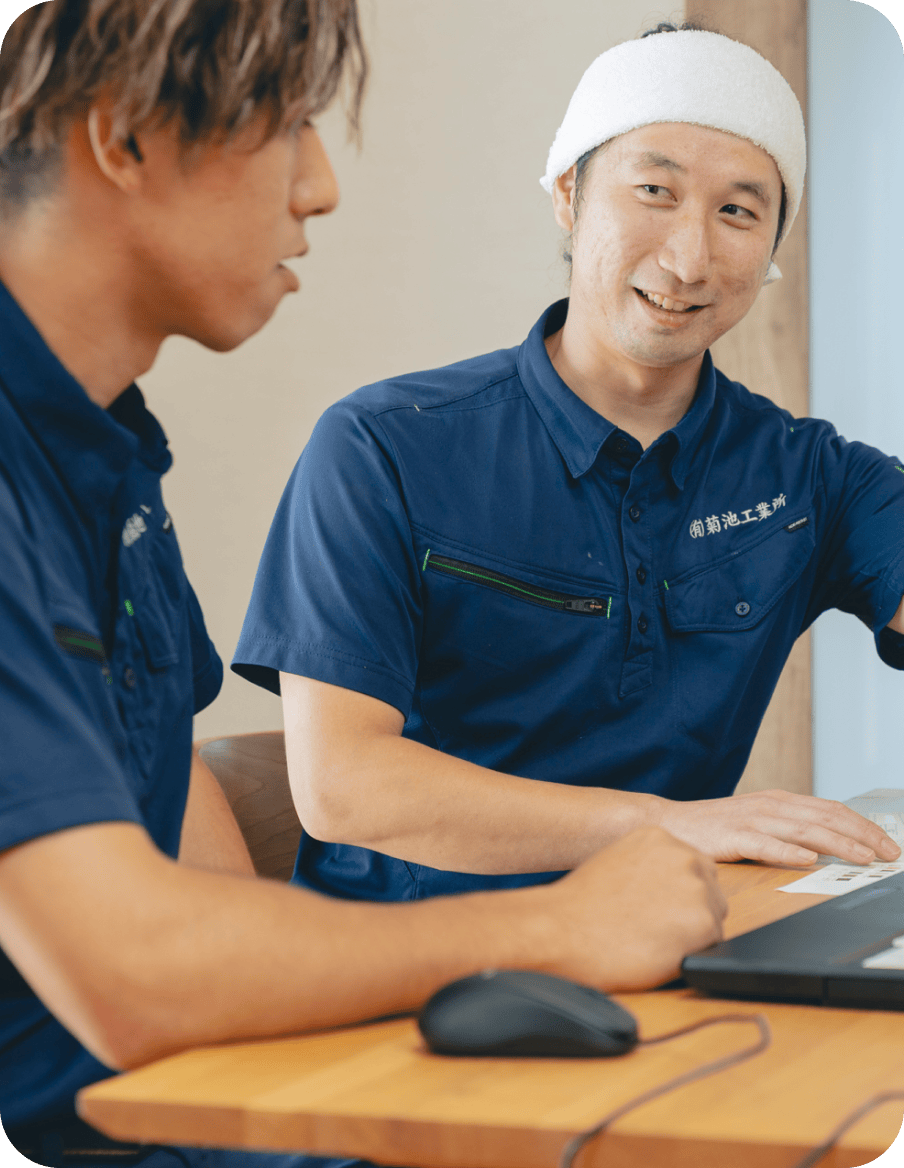 先輩と一緒に画面を見ながら作業を確認している様子